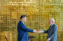 GPT Icon  Foto: Der chinesische Präsident Xi Jinping und der brasilianische Präsident Luiz Inácio Lula da Silva schütteln sich die Hände vor einer goldfarbenen Wand.