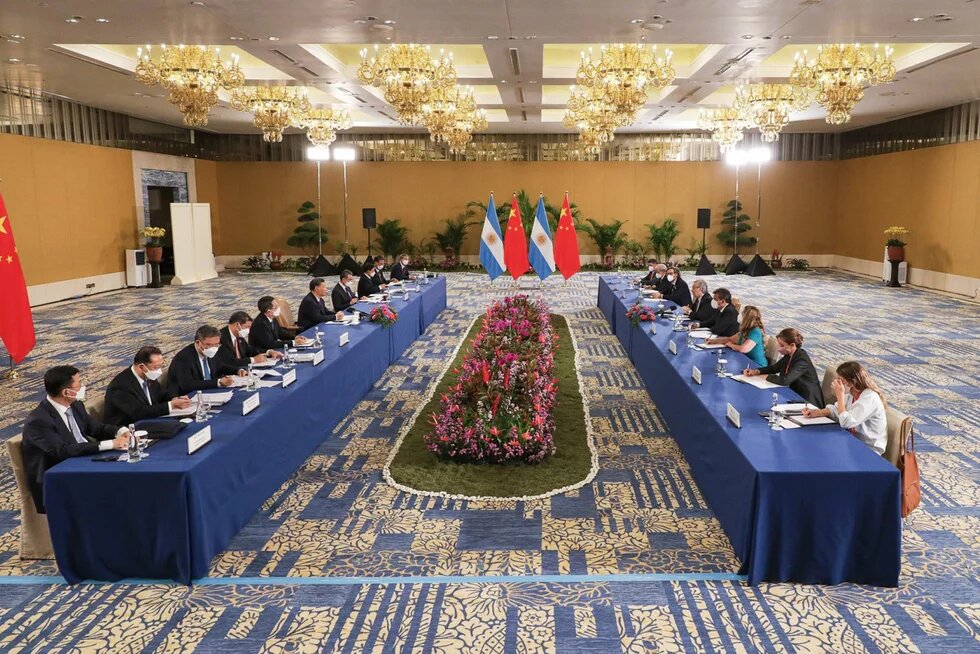 GPT Foto: Große Konferenz mit Delegationen aus China (links) und Argentinien (rechts) an zwei langen Tischen. In der Mitte stehen die Nationalflaggen beider Länder.